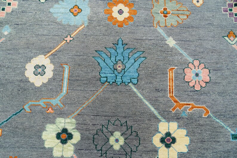 Hand-knotted wool rug in floral Turkish Oushak style, 8x10; blue-gray field with teal, rust, and peach blossoms.