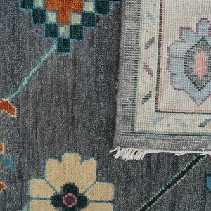 Hand-knotted wool rug in floral Turkish Oushak style, 8x10; blue-gray field with teal, rust, and peach blossoms.