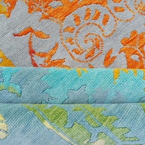 Hand-knotted wool Oushak rug in paisley pattern; rolled samples in teal, blue, orange for a textured floor decor rug.