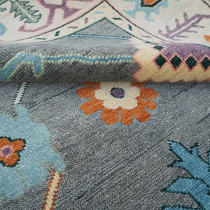 Hand-knotted wool rug in floral Turkish Oushak style, 8x10; blue-gray field with teal, rust, and peach blossoms.