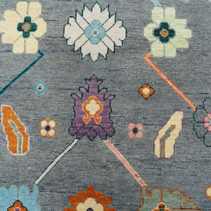 Hand-knotted wool rug in floral Turkish Oushak style, 8x10; blue-gray field with teal, rust, and peach blossoms.