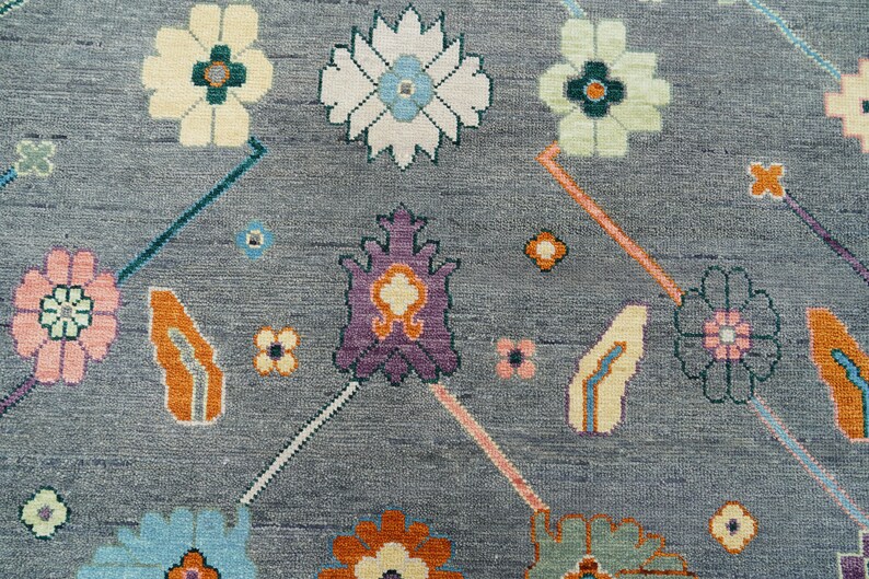 Hand-knotted wool rug in floral Turkish Oushak style, 8x10; blue-gray field with teal, rust, and peach blossoms.