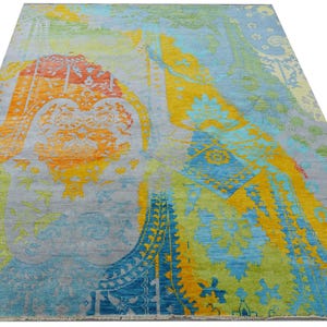 Hand-knotted wool Oushak rug in paisley pattern; rolled samples in teal, blue, orange for a textured floor decor rug.