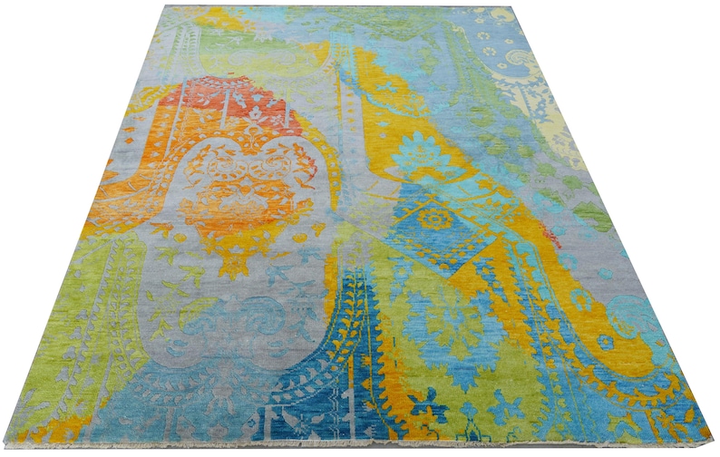 Hand-knotted wool Oushak rug in paisley pattern; rolled samples in teal, blue, orange for a textured floor decor rug.