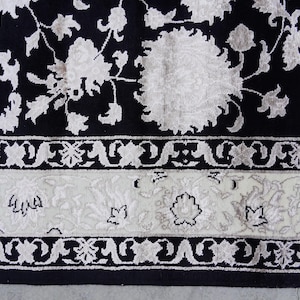 A 5.5x7.9 ft hand-knotted rug featuring a large, ornate ivory and blue central medallion on a deep navy blue field. The field is filled with intricate scrolling vines and small floral motifs. A wide, multi-layered border in ivory and light blue frames the rug. The rug is made of wool with silk highlights that give it a subtle sheen, finished with a short white fringe at the top and bottom.