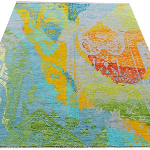 Hand-knotted wool Oushak rug in paisley pattern; rolled samples in teal, blue, orange for a textured floor decor rug.