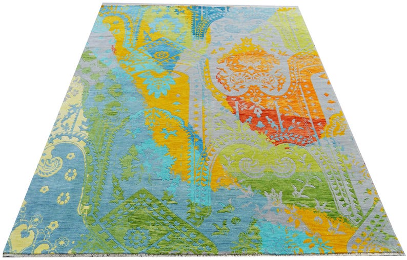 Hand-knotted wool Oushak rug in paisley pattern; rolled samples in teal, blue, orange for a textured floor decor rug.