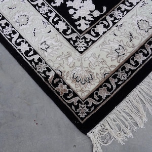 A 5.5x7.9 ft hand-knotted rug featuring a large, ornate ivory and blue central medallion on a deep navy blue field. The field is filled with intricate scrolling vines and small floral motifs. A wide, multi-layered border in ivory and light blue frames the rug. The rug is made of wool with silk highlights that give it a subtle sheen, finished with a short white fringe at the top and bottom.
