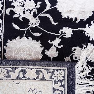 A 5.5x7.9 ft hand-knotted rug featuring a large, ornate ivory and blue central medallion on a deep navy blue field. The field is filled with intricate scrolling vines and small floral motifs. A wide, multi-layered border in ivory and light blue frames the rug. The rug is made of wool with silk highlights that give it a subtle sheen, finished with a short white fringe at the top and bottom.