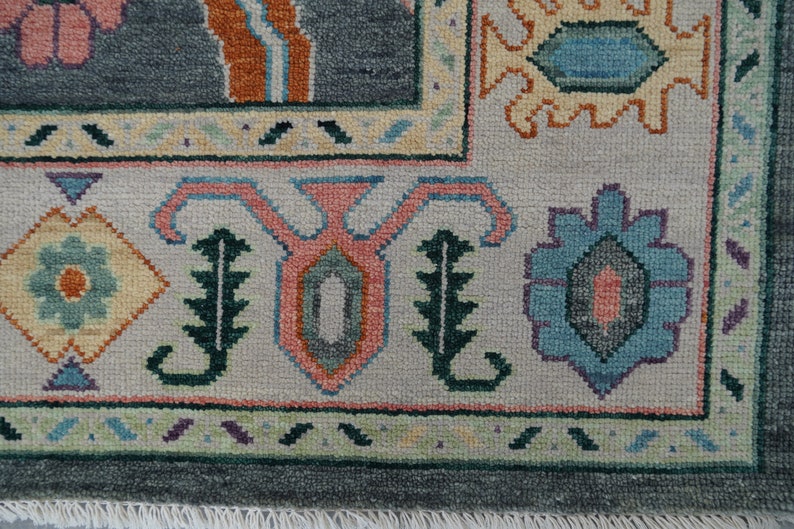 Hand-knotted wool rug in floral Turkish Oushak style, 8x10; blue-gray field with teal, rust, and peach blossoms.