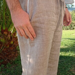 Puede incluir: Pantalones de lino color beige con cintura con cord&oacute;n y bolsillos laterales. Los pantalones tienen un ajuste relajado y una apariencia texturizada. El modelo lleva una camisa blanca. Adecuado para uso casual.