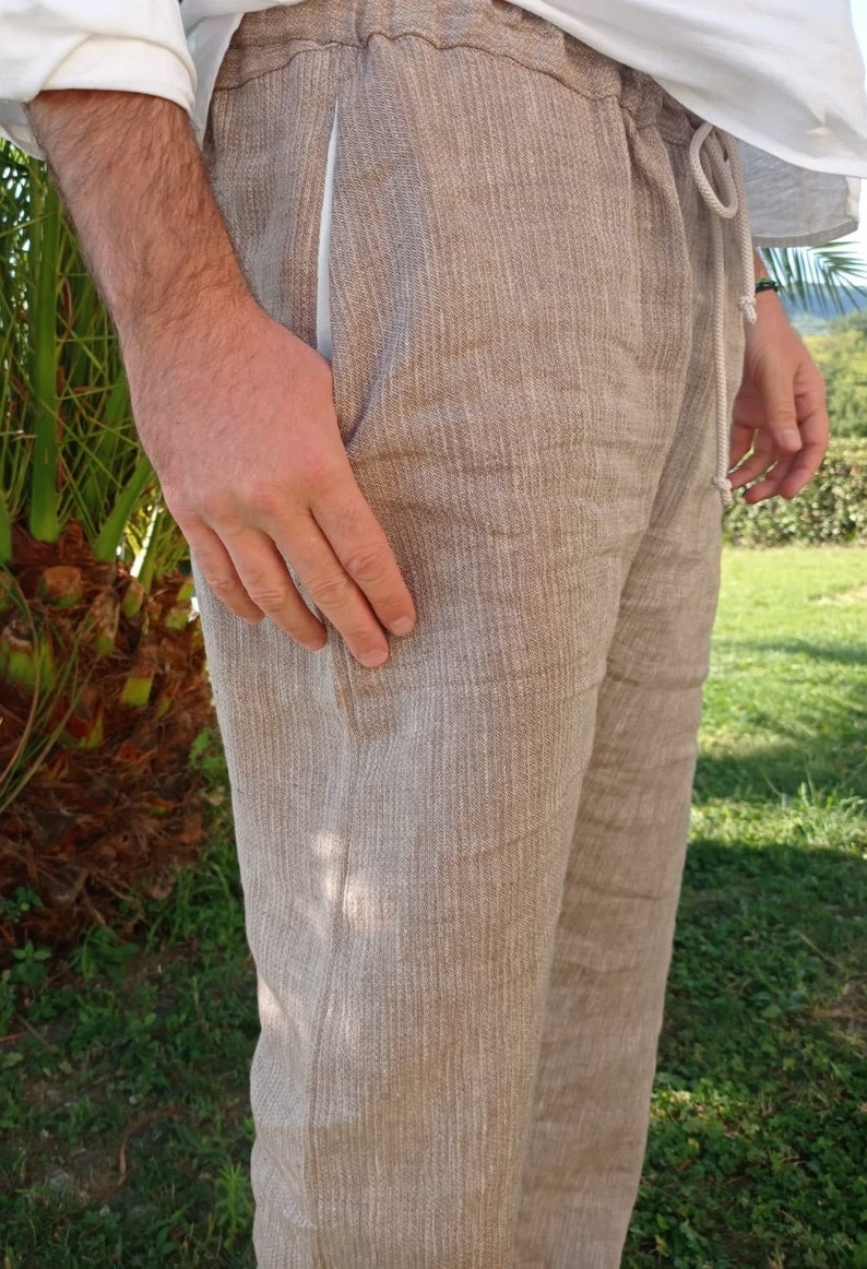Puede incluir: Pantalones de lino color beige con cintura con cord&oacute;n y bolsillos laterales. Los pantalones tienen un ajuste relajado y una apariencia texturizada. El modelo lleva una camisa blanca. Adecuado para uso casual.