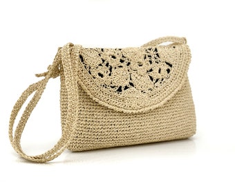 May include: A beige crocheted crossbody bag with a circular crocheted design on the flap.