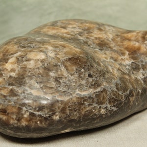 以下が含まれることがあります： 大理石模様の、滑らかで、茶色と白の、不規則な形の石