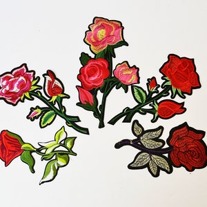 以下が含まれることがあります： 赤いバラとピンクのバラ、緑の葉と茎がついた刺繍のアイロン接着パッチが5つです。