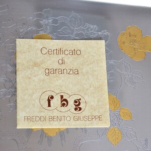 May include: A brown paper warranty certificate with the text "Certificato di garanzia" and the initials "fbg" for Freddi Benito Giuseppe.