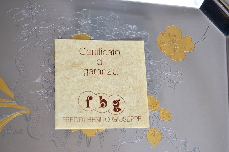May include: A brown paper warranty certificate with the text "Certificato di garanzia" and the initials "fbg" for Freddi Benito Giuseppe.