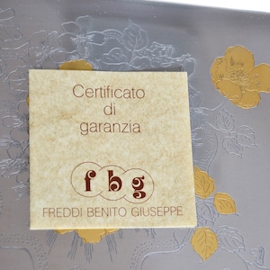May include: A brown paper warranty certificate with the text "Certificato di garanzia" and the initials "fbg" for Freddi Benito Giuseppe.