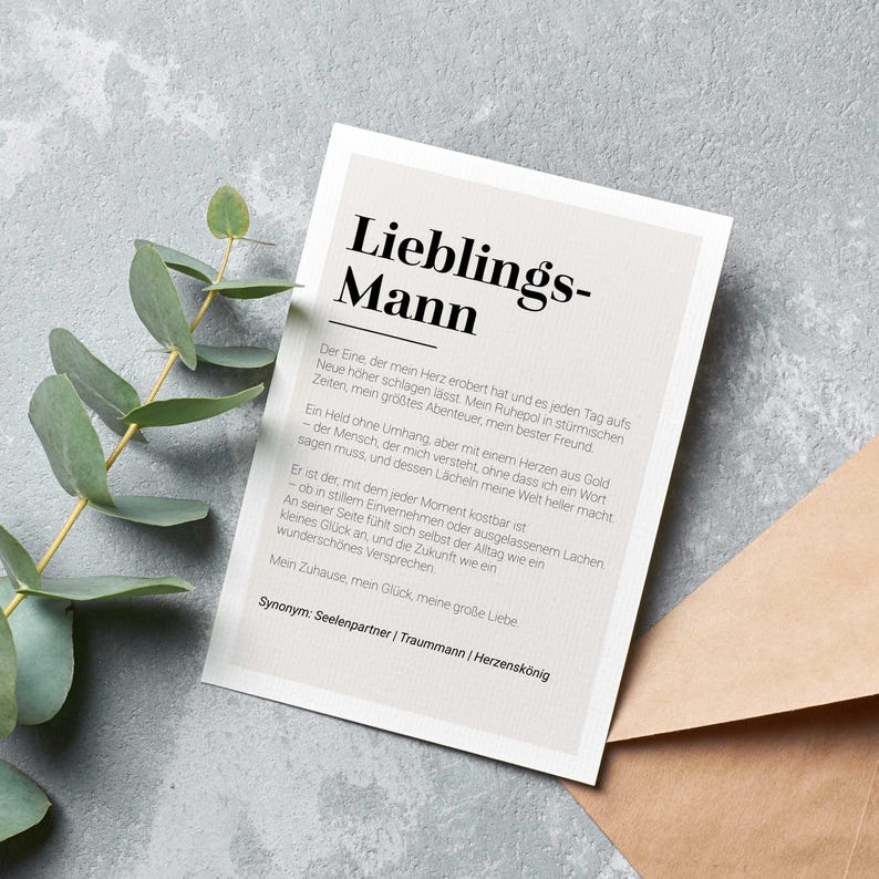 May include: A beige card with the text "Lieblings-Mann" in black lettering. The card features a definition of the word "Lieblings-Mann" in German, describing a person who is a partner, a dream, and a king of hearts. The text includes the synonyms "Seelenpartner", "Traummann", and "Herzensk&ouml;nig".
