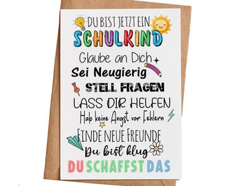 May include: A colourful card with the text "DU BIST JETZT EIN SCHULKIND" and other encouraging messages for a new student. The card features a lightbulb, a sun, a pencil, a pushpin, a lightning bolt, a paper aeroplane, and a daisy.