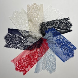 Puede incluir: Surtido de encajes en varios colores, incluyendo blanco, beige, negro, azul y rojo. Los encajes presentan delicados patrones florales y bordes festoneados.