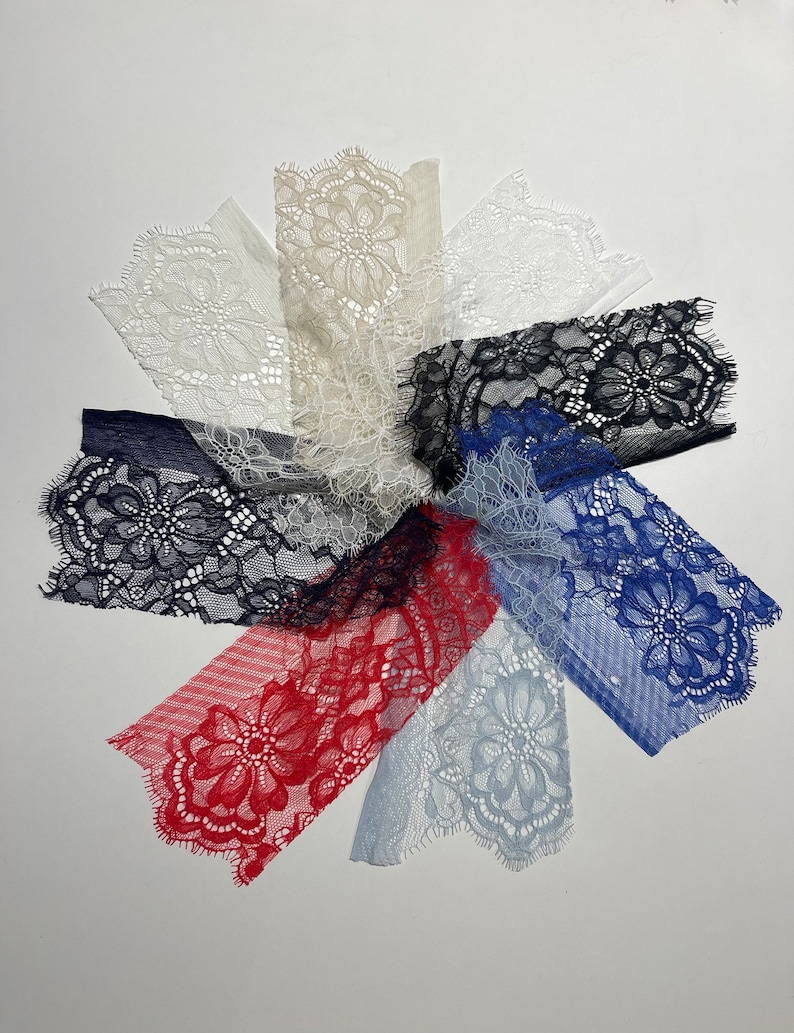 Puede incluir: Surtido de encajes en varios colores, incluyendo blanco, beige, negro, azul y rojo. Los encajes presentan delicados patrones florales y bordes festoneados.