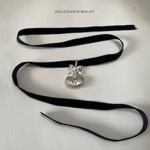 May include: A black velvet choker necklace with a silver pendant. The pendant features a bow and a heart-shaped charm with intricate detailing. The jewelry is displayed on a white surface. The text "VOLODARJEWELRY" is at the top.