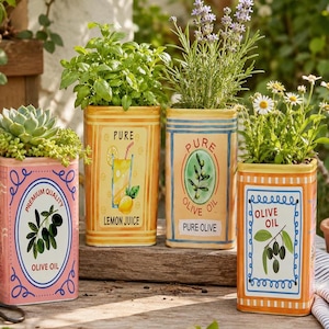 May include: Four rectangular ceramic planters designed to look like vintage metal tins. Each features colorful graphics of olives, lemons, and text including "Premium Quality Olive Oil," "Pure Lemon Juice," and "Pure Olive Oil," holding various green plants.