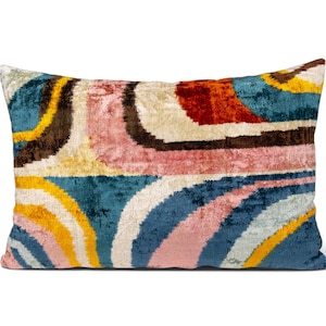 Può includere: Un cuscino rettangolare con una superficie testurizzata simile al velluto e un motivo astratto multicolore. Il design è composto da bande curve e fluide in tonalità blu ottanio profondo, giallo senape, rosa tenue, crema, marrone scuro e arancione bruciato.