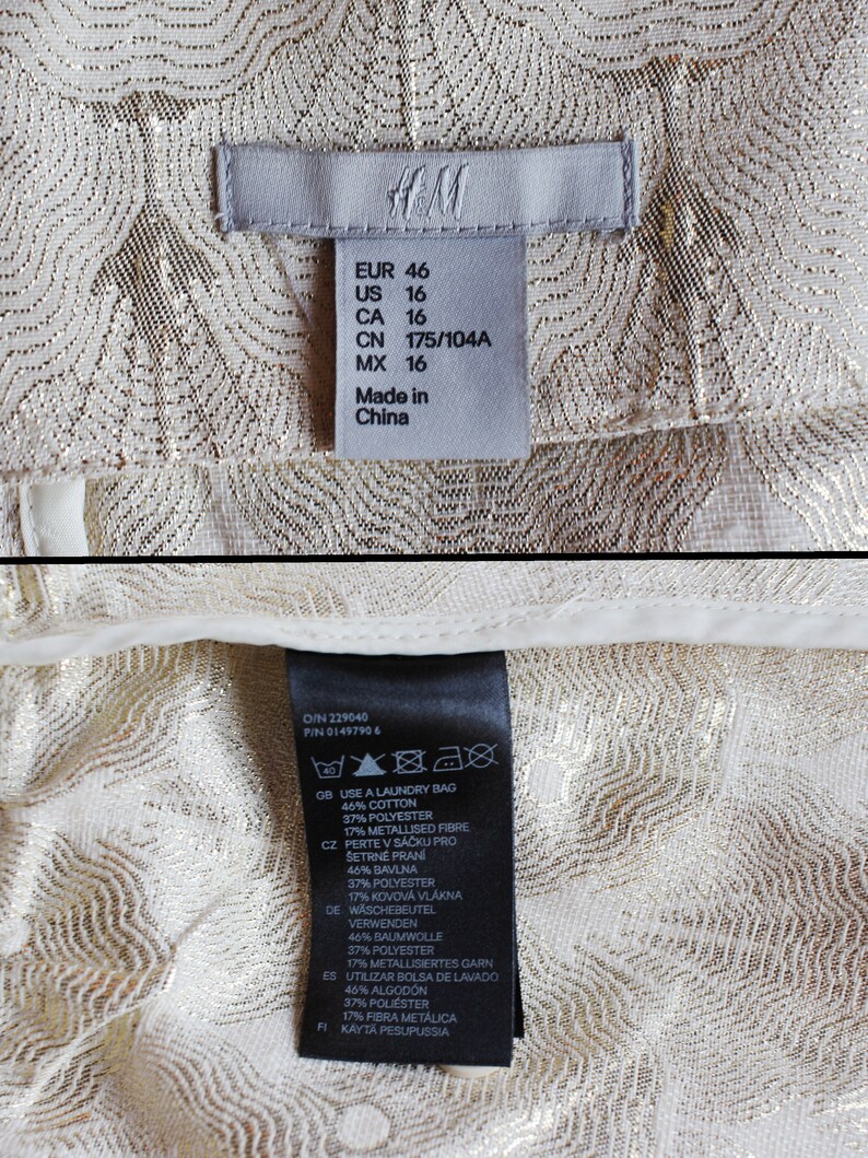 May include: A white tag with black text detailing the size and care instructions for a garment. The tag reads "EUR 46, US 16, CA 16, CN 175/104A, MX 16, Made in China". The care instructions include "Use a laundry bag, 46% cotton, 37% polyester, 17% metallised fibre".