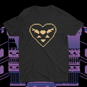 Puede incluir: Camiseta negra con un diseño de corazón pixelado amarillo. El corazón tiene un diseño de ala estilizado en su interior.
