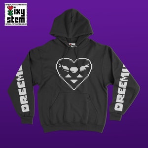 Puede incluir: Una sudadera con capucha negra con un diseño de corazón pixelado blanco en la parte delantera y la palabra "DREEM" impresa en las mangas.