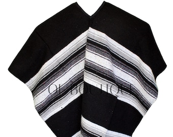 May include: A black and white striped poncho with a V-neck design. The poncho features alternating stripes of black, white, and gray. The bottom edge has a fringe detail. This traditional garment is suitable for various occasions.