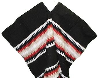 May include: Black and white striped poncho with red accents. The poncho has a fringe border.