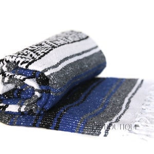 May include: A rolled up blue, white, black, and gray striped Mexican blanket with white fringe.