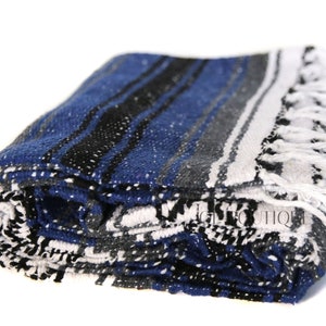 May include: A folded blue, white, and black striped Mexican blanket with white fringe.