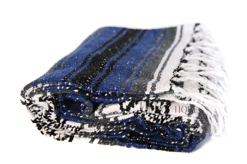 May include: A folded blue, white, and black striped Mexican blanket with white fringe.