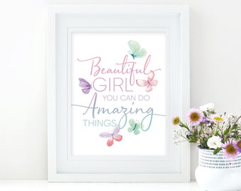 以下が含まれることがあります： 「Beautiful Girl You Can Do Amazing Things」という文字が筆記体で書かれた、ピンク、紫、水色の水彩画の蝶が描かれたフレームプリント。白いフレームに入っています。