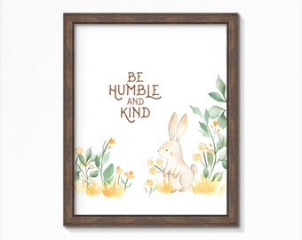 May include: A watercolor print with a white rabbit holding a bouquet of yellow flowers. The print features the text "Be Humble and Kind" in brown lettering.