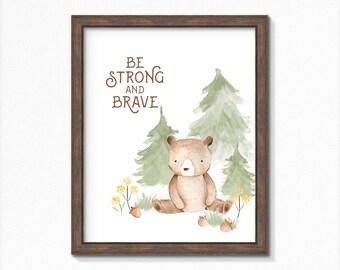 May include: A watercolor illustration of a brown bear sitting in a forest with green trees and yellow flowers. The text "Be Strong and Brave" is written in brown lettering above the bear.