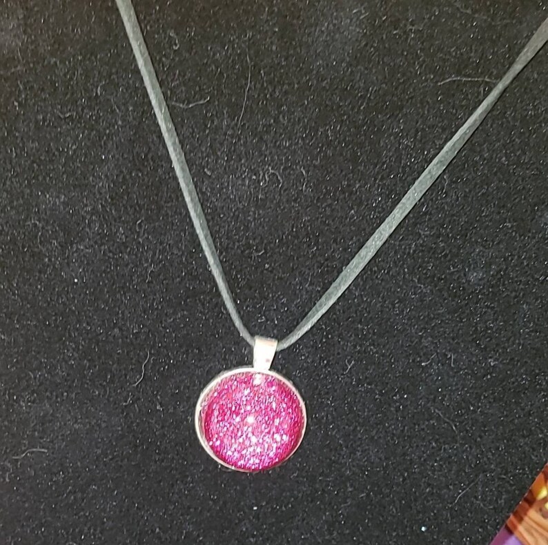 Pink glitter circle charm necklace.