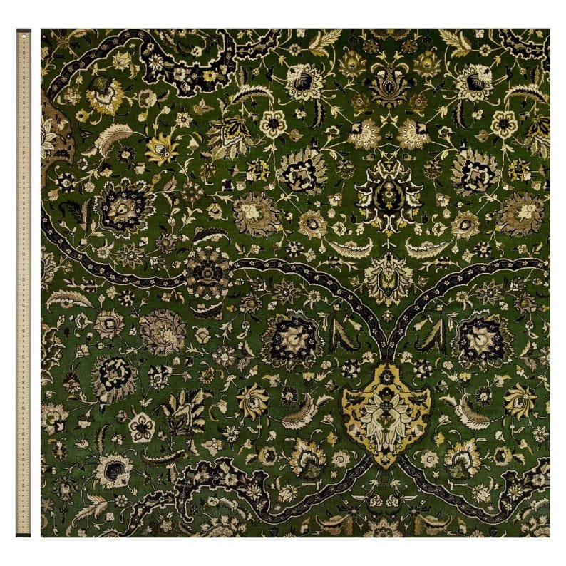 May include: A green rug with a floral pattern. The rug has a central medallion with a more intricate design. The rug is made of wool and silk.