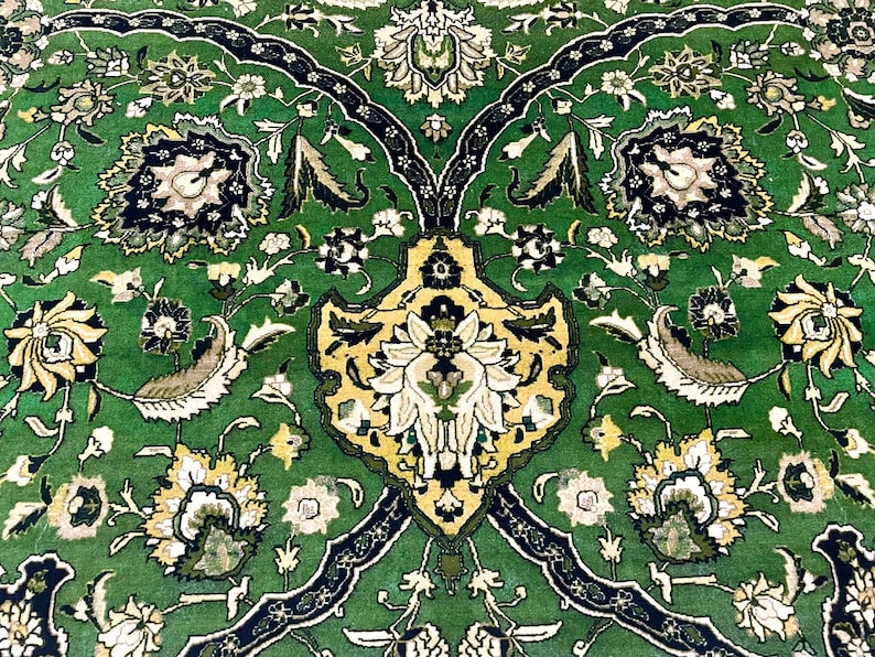May include: A green rug with a floral pattern. The rug has a central design with a yellow and white flower. The rug is made of a soft, plush material.