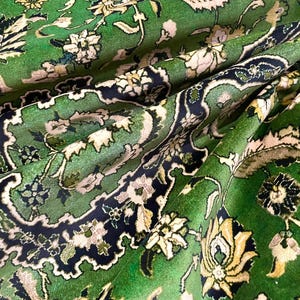 May include: A green rug with a floral pattern. The rug has a traditional Persian design with intricate details and a rich color palette.
