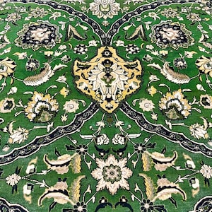 May include: A green rug with a floral pattern in shades of white, yellow, and black. The rug has a symmetrical design with a central motif.