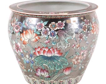 May include: A large, round ceramic planter with a dark gray background and a floral design. The flowers are in shades of pink, orange, blue, and white. The planter has a wide rim and a decorative border at the base.