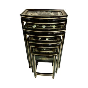 May include: A set of five black nesting tables with gold trim. Each table features a rectangular top with a curved edge and decorative inlaid designs. The tables are stacked, showcasing their graduated sizes and intricate details.