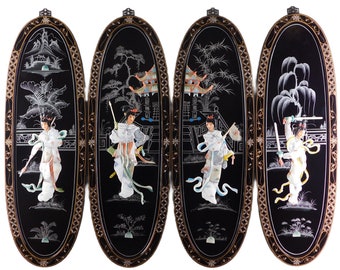 May include: Four black, oval wall panels with ornate gold trim. Each panel features a detailed, inlaid scene of figures in traditional dress, with landscapes and architectural elements. The figures are in white, with colorful accents.