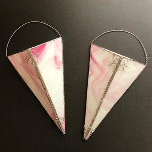 May include: Two pink and white stained glass hanging planters with silver wire accents. The planters are shaped like cones and have a swirl pattern.