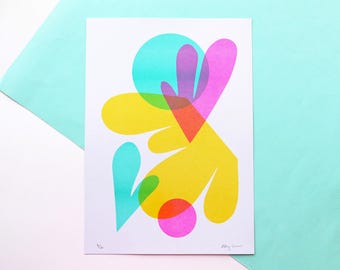 May include: Abstract art print featuring overlapping shapes in yellow, pink, blue, green, and purple. The print has a white background and is signed "Allie James".